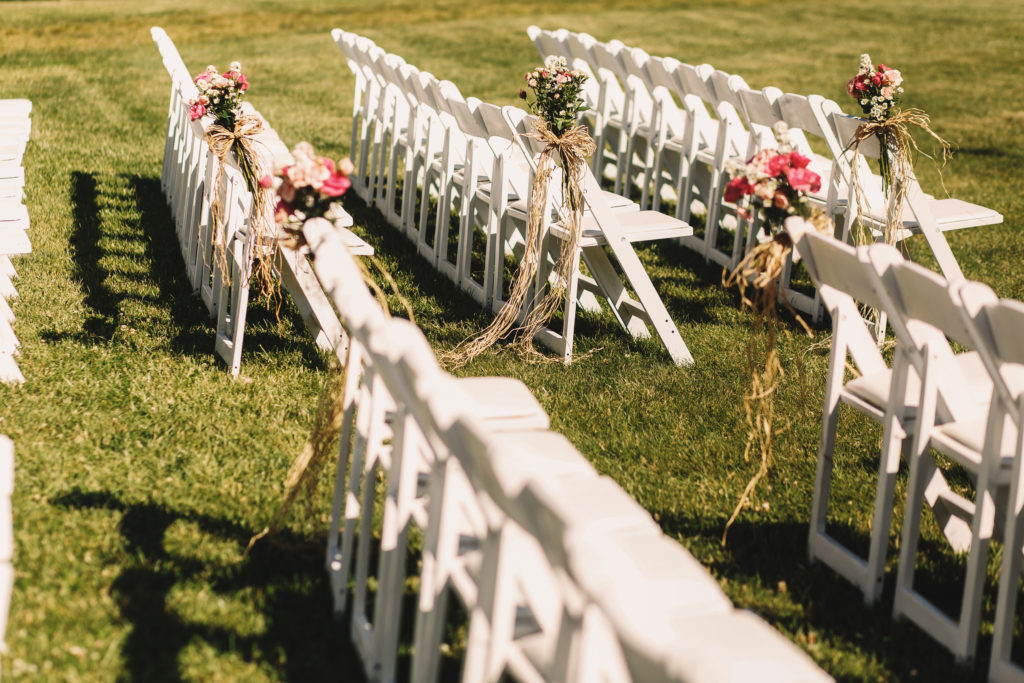White chairs stand in long rows waiting for the beginning of wedding ceremony